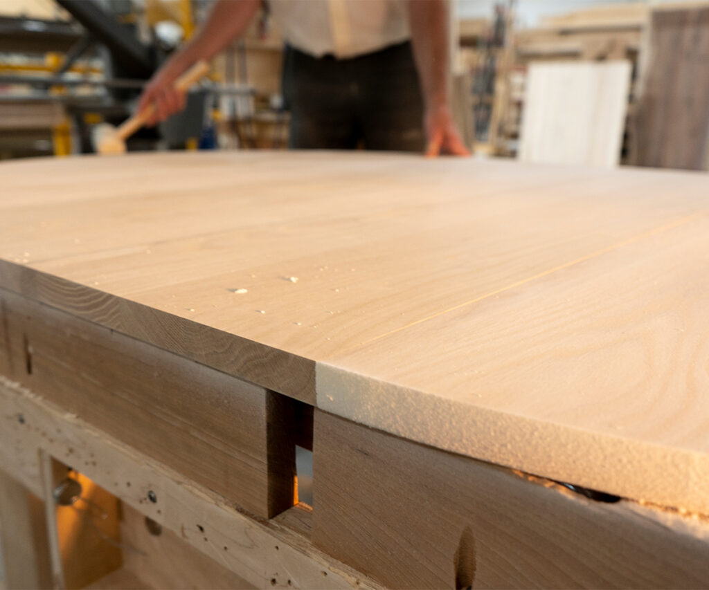 Why Americans Are Buying Amish-Made Furniture 2 Solid hardwood tabletop with visible joinery in an Amish furniture workshop